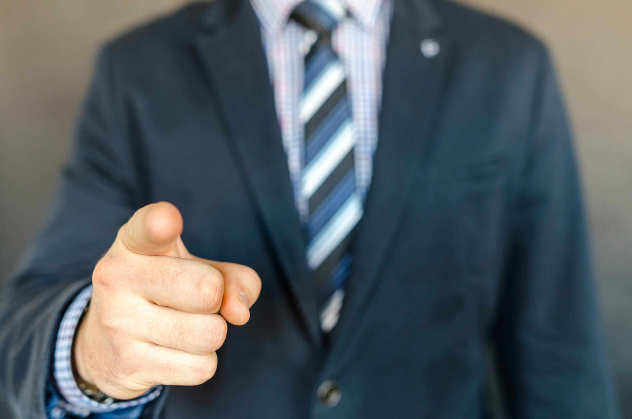 Man in a suit pointing at the camera